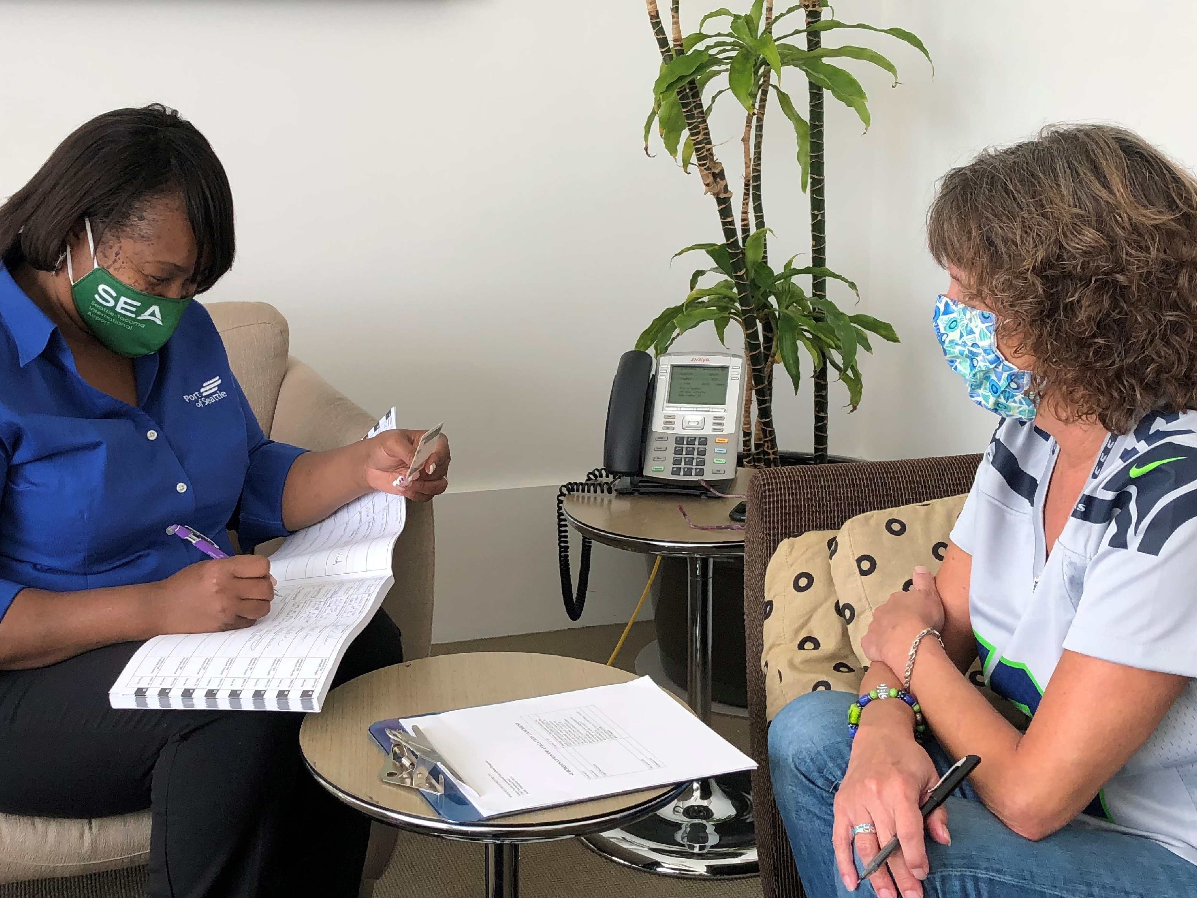 An employee taking notes while speaking with a client.