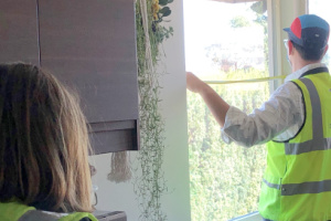 Worker measuring a window inside of a residential home.