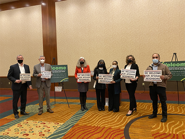 Partners including local businesses in SeaTac and state reps pose in solidartdy holding "We Welcome Our Afghan Neighbors" placards.
