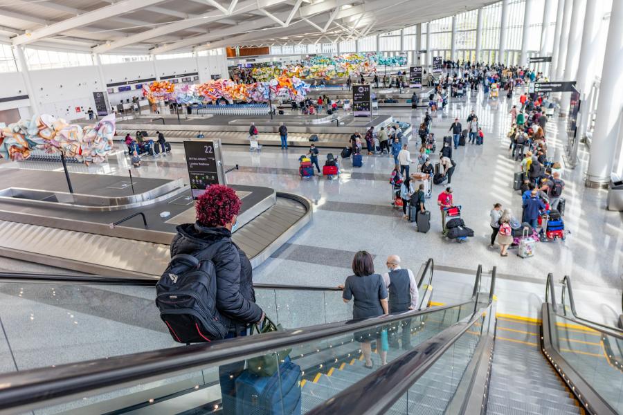 the new International Arrivals Facility (IAF) is fully open to welcome you home! &nbsp;A photo of passengers collecting luggage. 