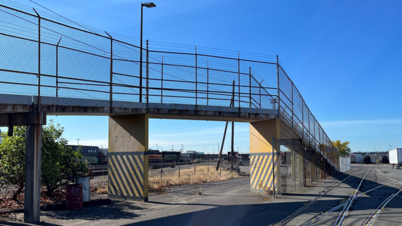 A cycling path in a trainyard raised high above the ground.