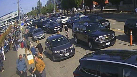 Cyclist navigating through heavy, chaotic car traffic.