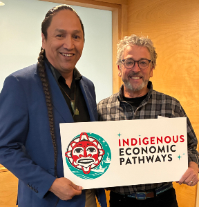 Felleman and a colleague hold a sign reading 'Indigenous Econmic Pathways'.