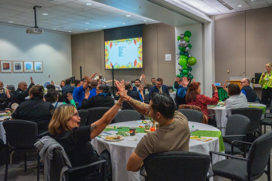 Two airport employees high five a workforce celebration event.