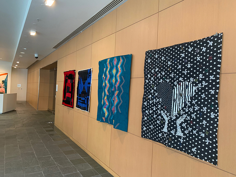 Quilts displayed on the wall.