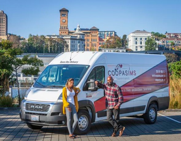 Markiss and Ashley in front of their company van labeled ‘COOPASIMS Transportation and Logistics.