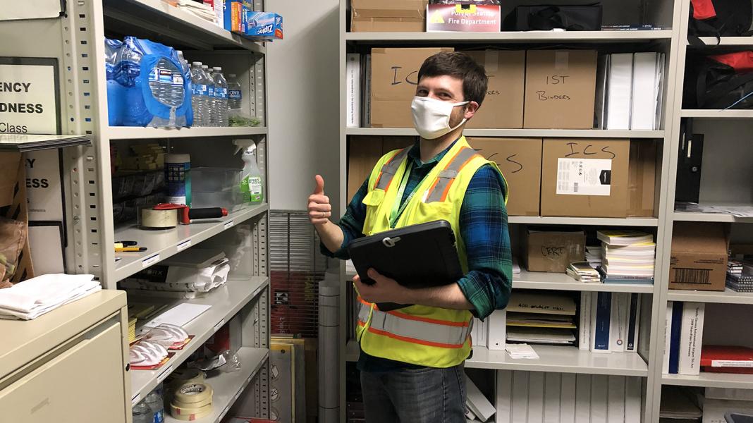 Gerard Checchia in a neon vest and face mask in a supply room.