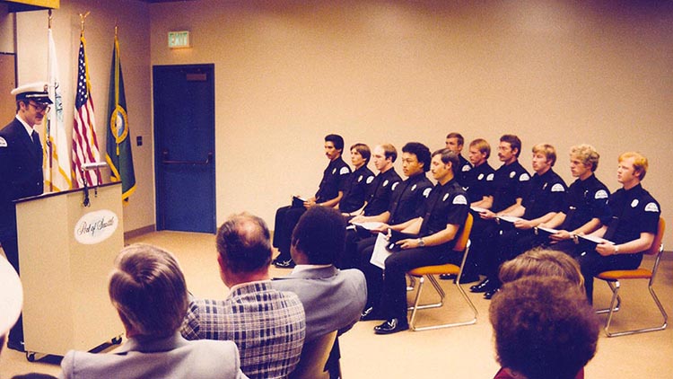 Officers seated in rows, with a presenter at a podium.