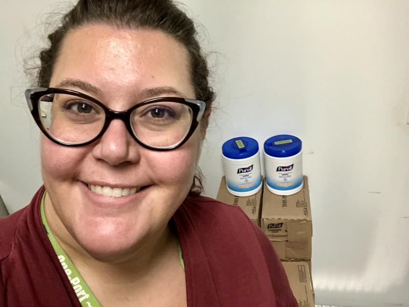 Kati Davich in front of cleaning supplies.