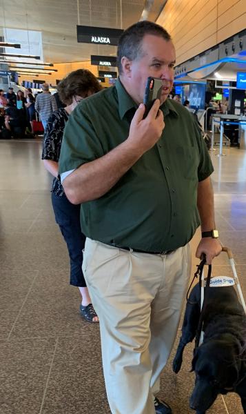 Larry and his service dog Huey navigate the airport using Aira technology.