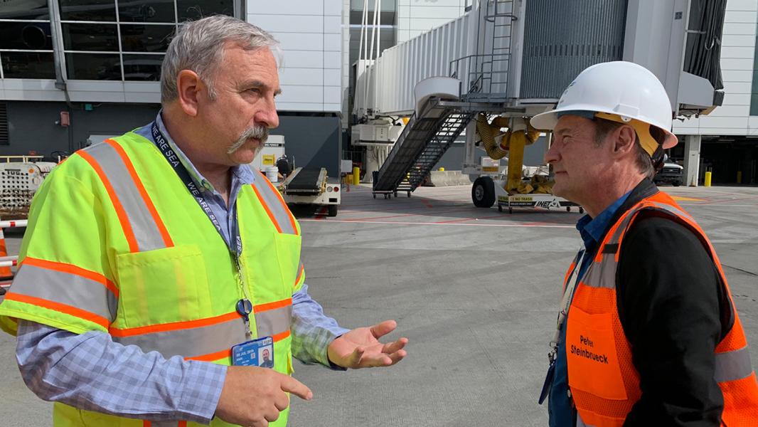 Paul Pelton talks with Commissioner Steinbrueck on the airfield at Sea-Tac Airport.