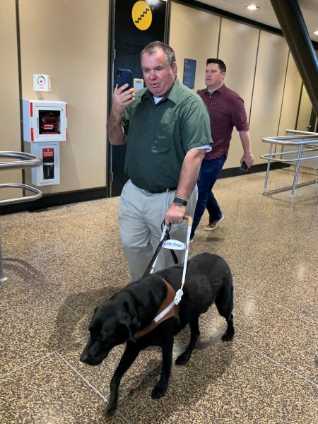 Larry Watkinson demonstrates the use of Aira and how it helps him navigate the airport.