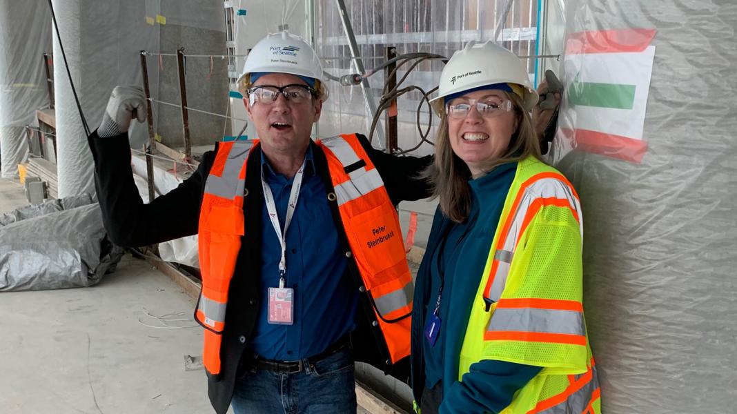 Janet Sheerer and Commissioner Steinbrueck in the new International Arrivals Facility under construction at Sea-Tac Airport.