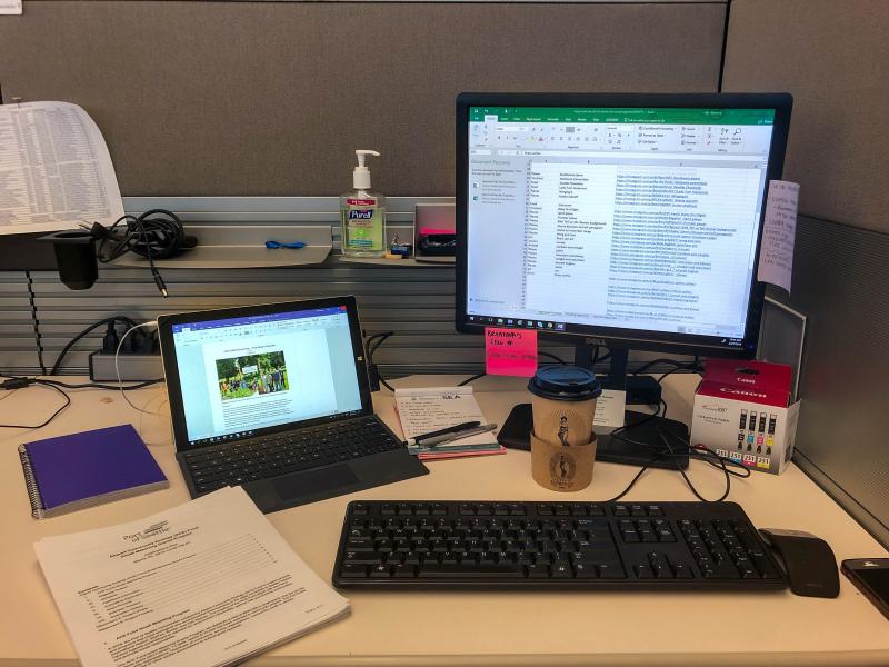 Image of a desk with tools: a computer, notepad.