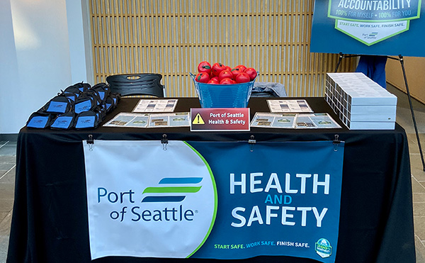 Port of Seattle Health and Safety Display Table, with banner in front that says Port of Seattle - Health and Safety.