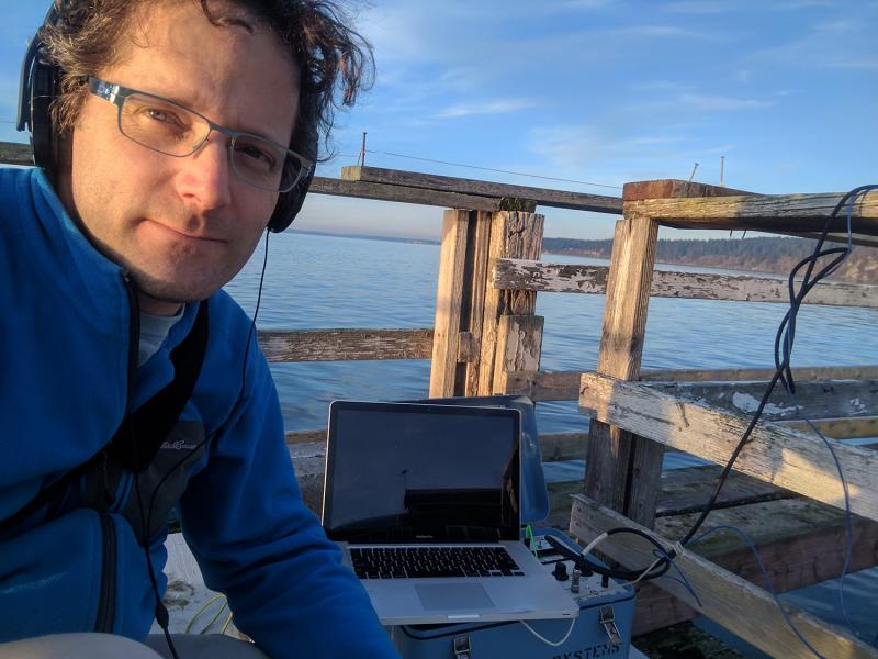 Scott Veirs with a laptop on a pier.