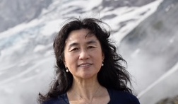A headshot of Huaqi Yin standing outside