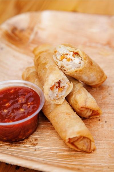 Egg rolls with a side of sauce.