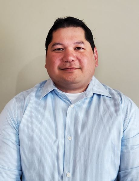 Jon Eustaquio in a light blue button‑down shirt, looking at the camera with a neutral expression against a plain background.