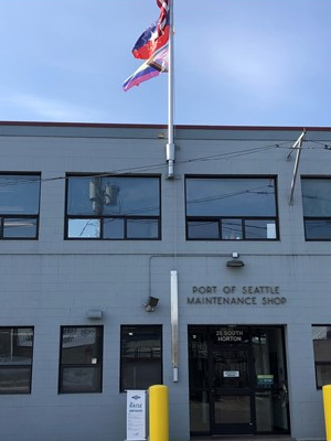 Horton Street facility of Maritime Maintenance with Pride and Juneteenth flags flying above.