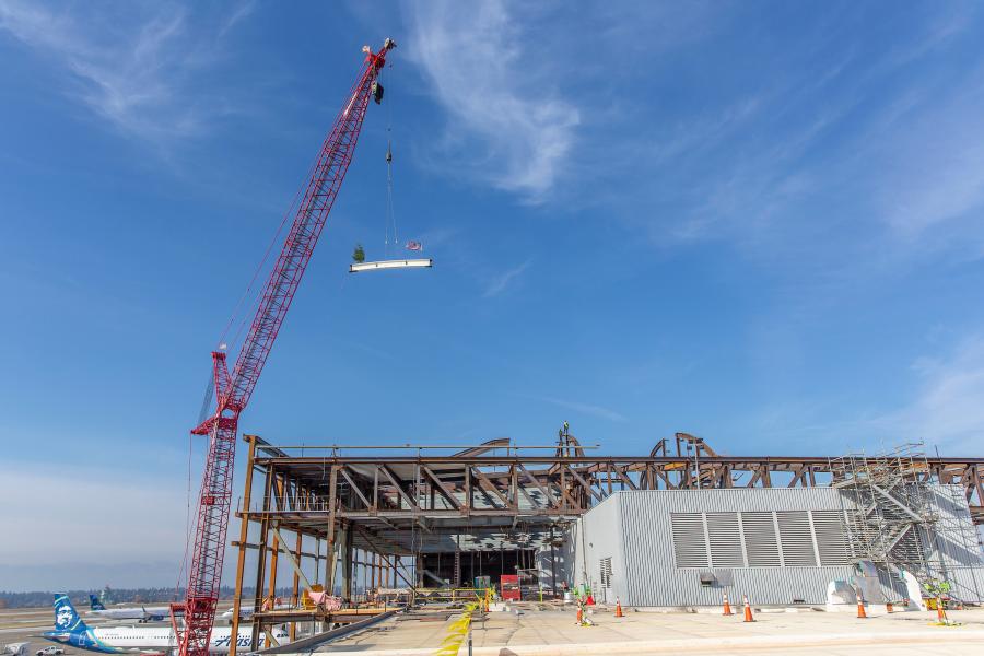 Topping off ceremony at the North Satellite with big crane and steel beam.