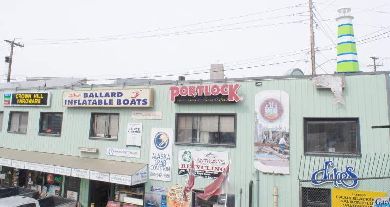 The Side of Pacific Fishermen's Shipyard with signs from old Ballard institutions.