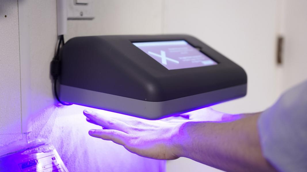 A purple light shines on a pair of hands.