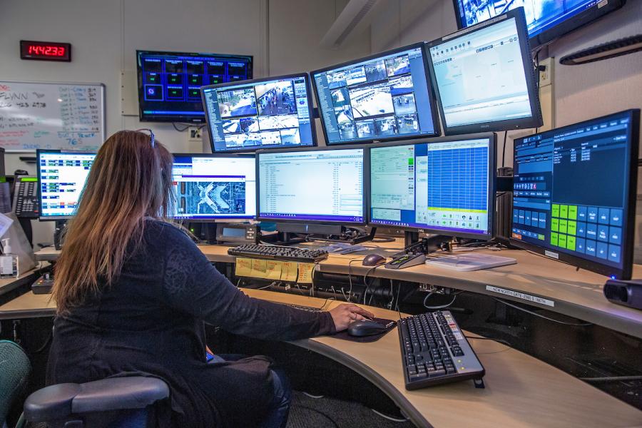 Operator sitting at a curved desk with 8 different monitors open.