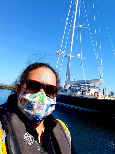 Lani Jellings wearing a face mask in front of a boat.