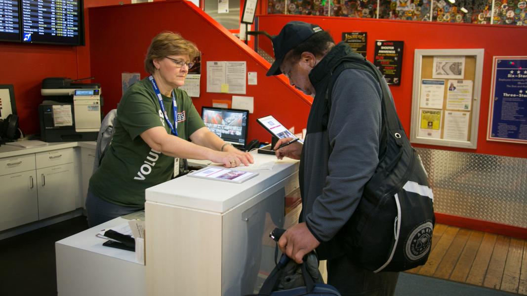 Jeanne helping a veteran at the USO help desk.