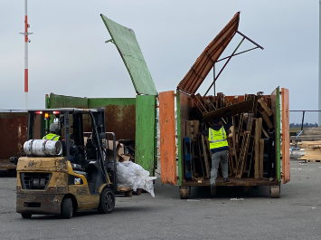 Port of Seattle staff disposing of wood in designated dumpster.