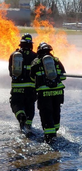 Two firefighters headed towards a fire.