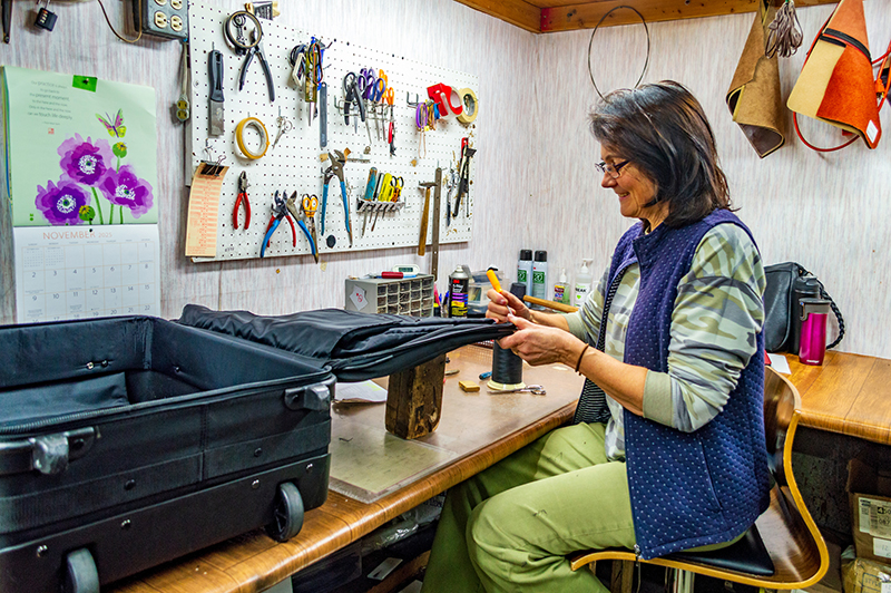 TW Carrol repair specialist works on a piece of luggage.