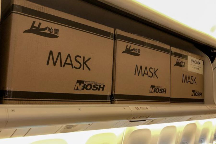 Boxes of masks in the overhead bins.