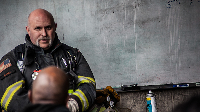Todd Starkey in uniform, in front of a whiteboard.