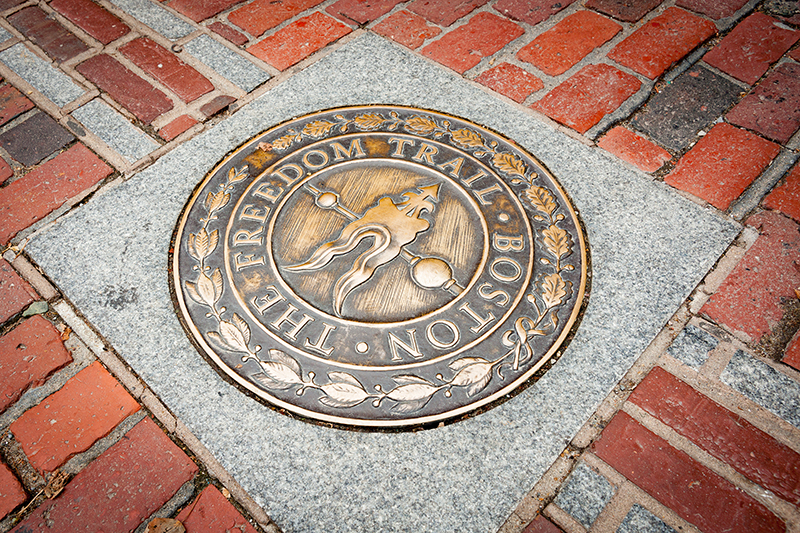 Freedom Trail symbol on a brick path.
