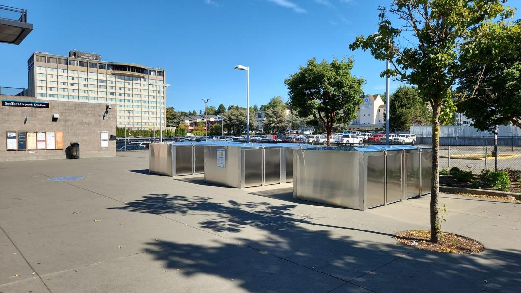 Approximately 12 bike lockers that are rectangle in shape.