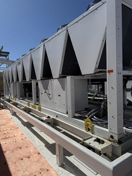 Outdoor photo of large industrial heat‑pump units installed on a metal platform.