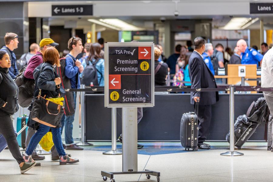 Travelers passing through a security checkpoint lane at SEA Airport