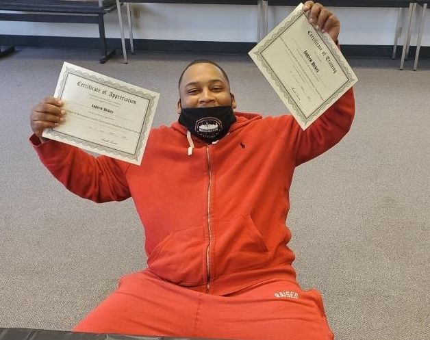 Graduate showing off his certificates.