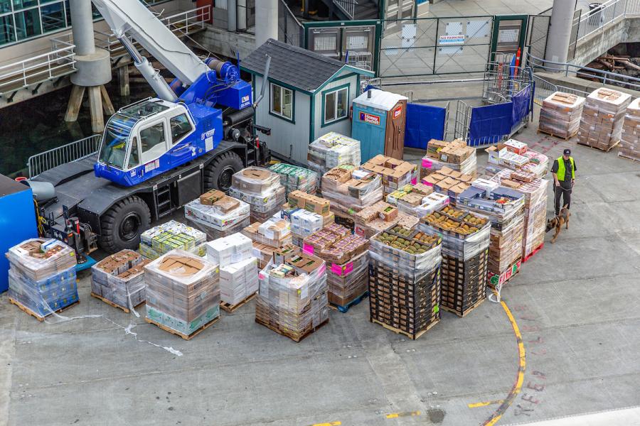 Cruise ship being loaded with fruits, vegetables, and flowers.
