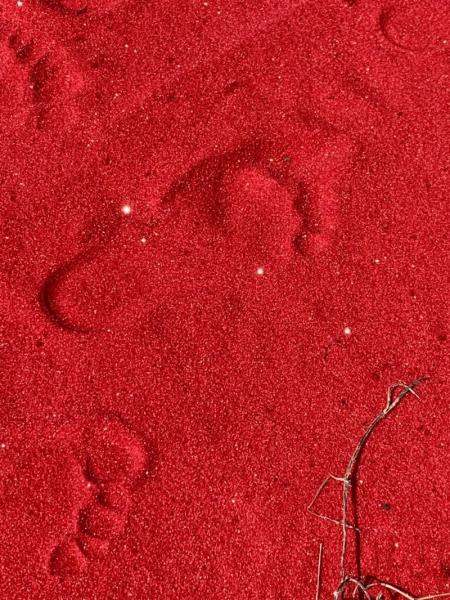 Red sand with footprints.