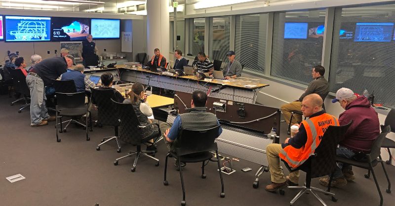 A conference room with the Snow Team seated in a round formation.