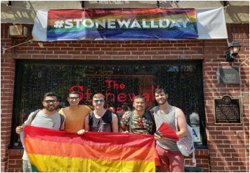 Tunny Vann and friends hold a pride flag.