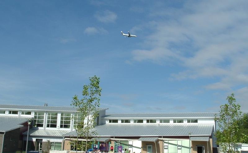 Image of school with airplane flying overhead