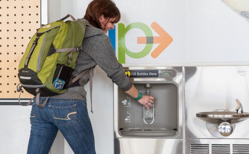 Customer filling bottle at a refill station 