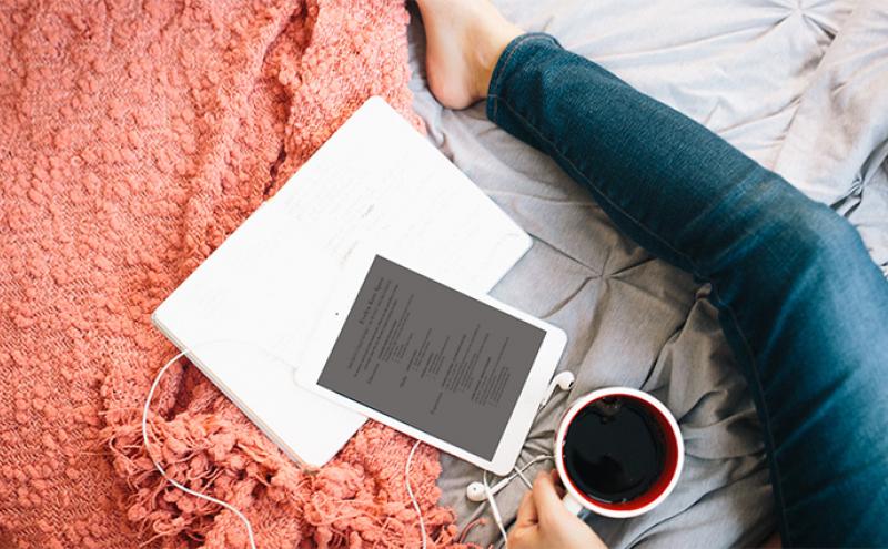 Person works on their resume in bed