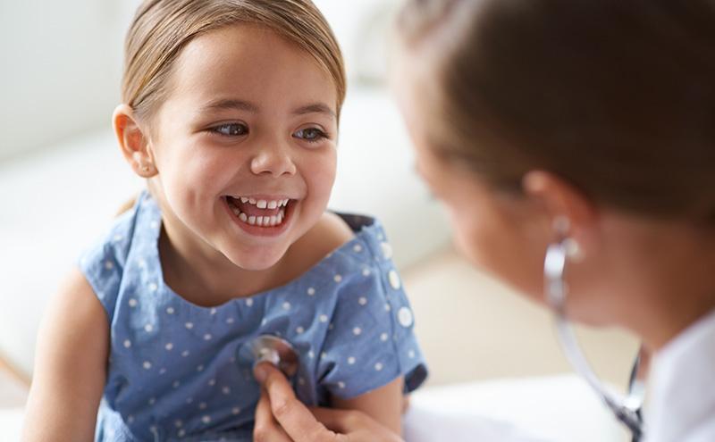Doctor checks smiling girls heart-rate