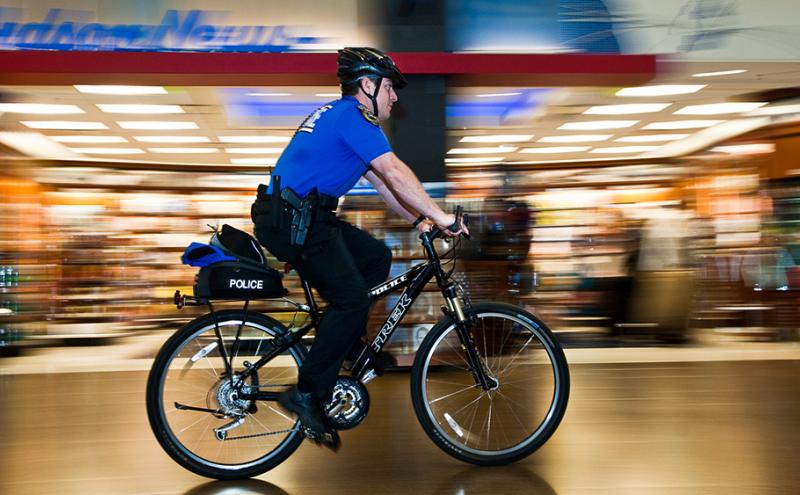Officer riding a bike through an indoor setting.