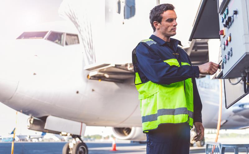 Airfield worker toggles the controls of a et bridge